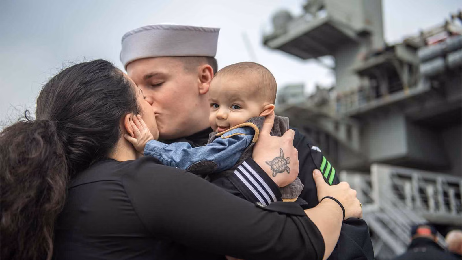 A sailor reunites with his family on the pier during the homecoming of the USS Abraham Lincoln.